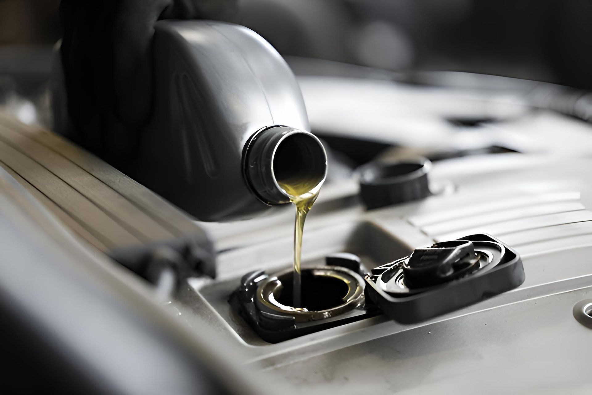 A Bottle of Oil is Being Poured Into a Car Engine — Mid Coast Bearing Centre in Bulahdelah, NSW