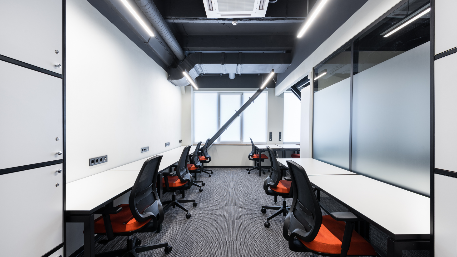 A room with a lot of desks and chairs in it.