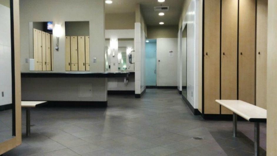 A locker room with lots of lockers and a bench