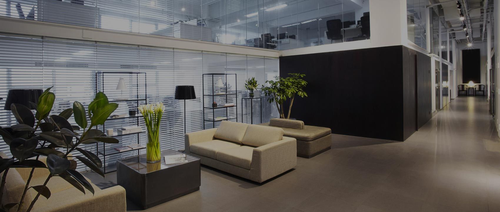 A living room in an office building with a couch and a table.