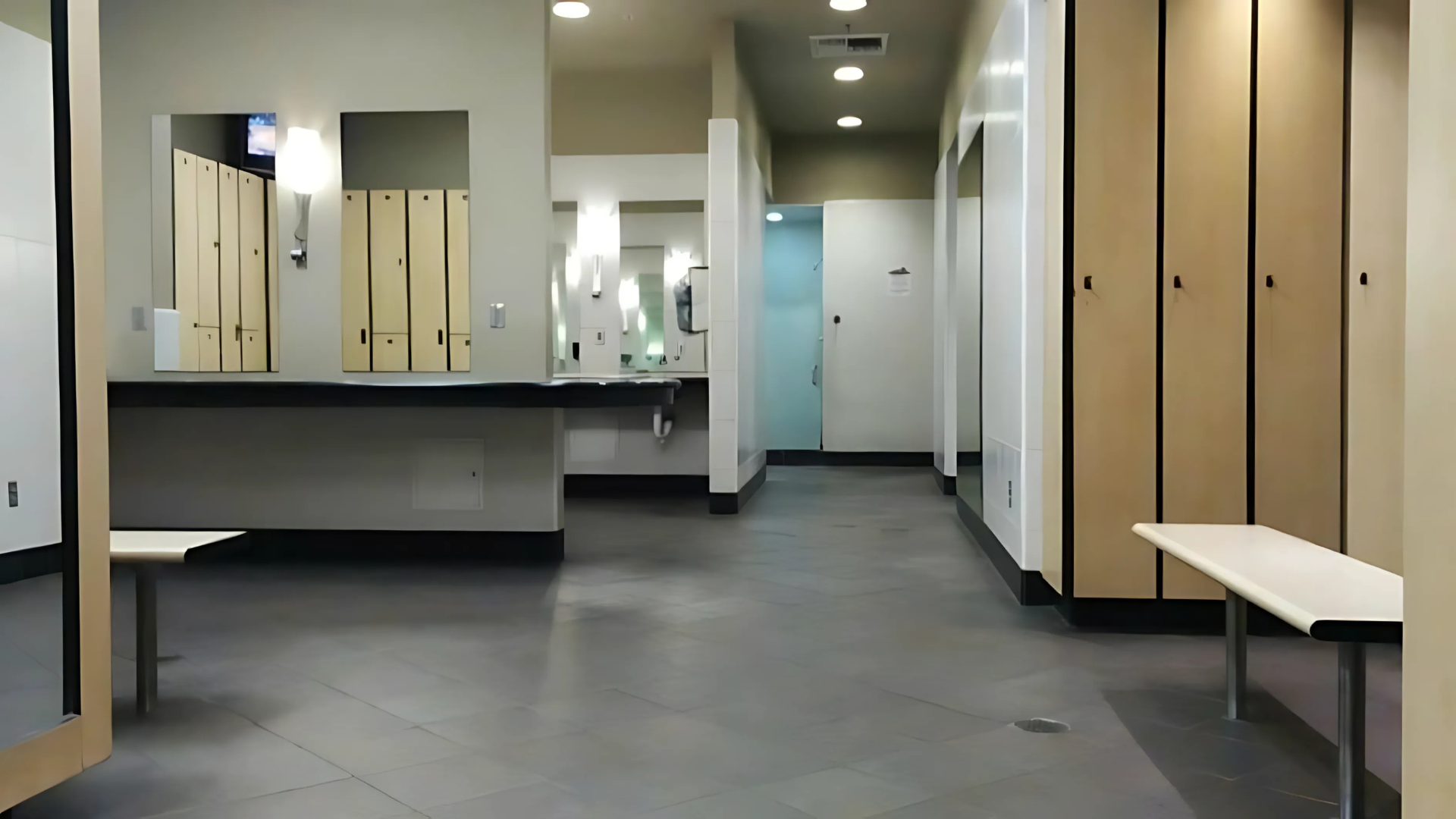 An empty locker room with wooden lockers and a bench