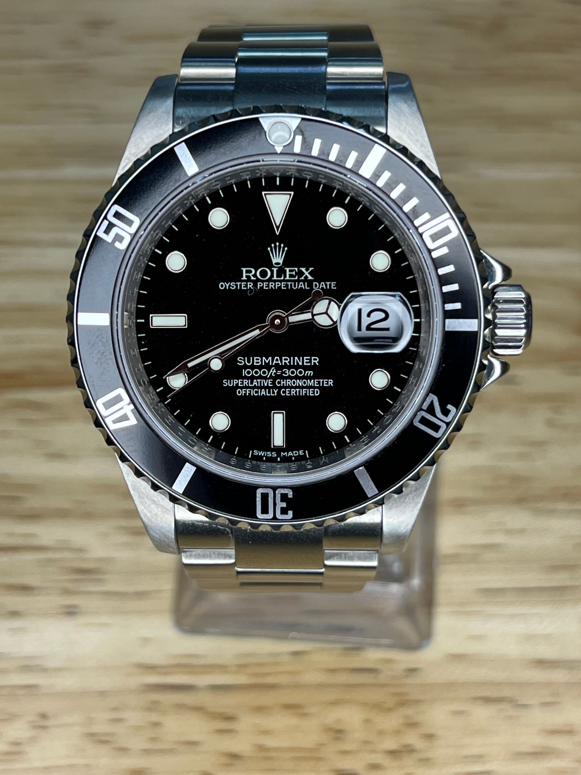 Stainless steel Rolex Submariner watch with a black dial, black bezel, and silver bracelet.