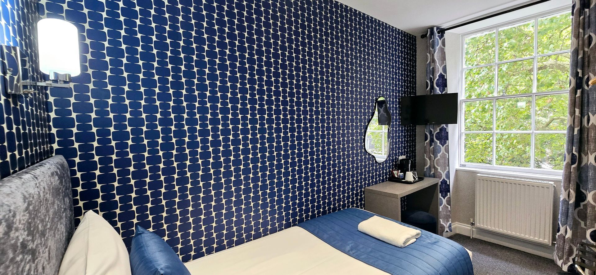 A hotel room with a bed , desk and television