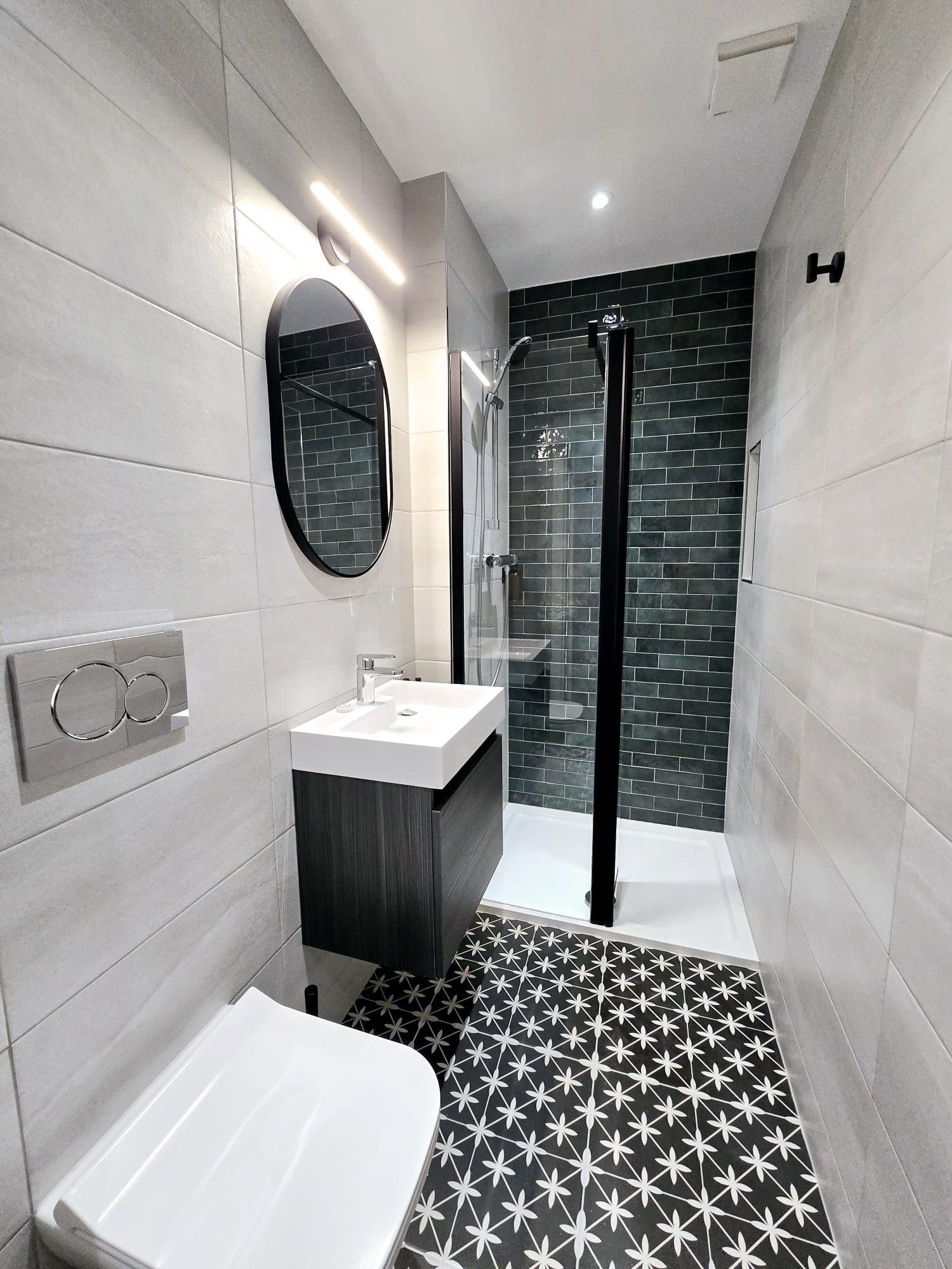A bathroom with a toilet , sink , mirror and walk in shower.