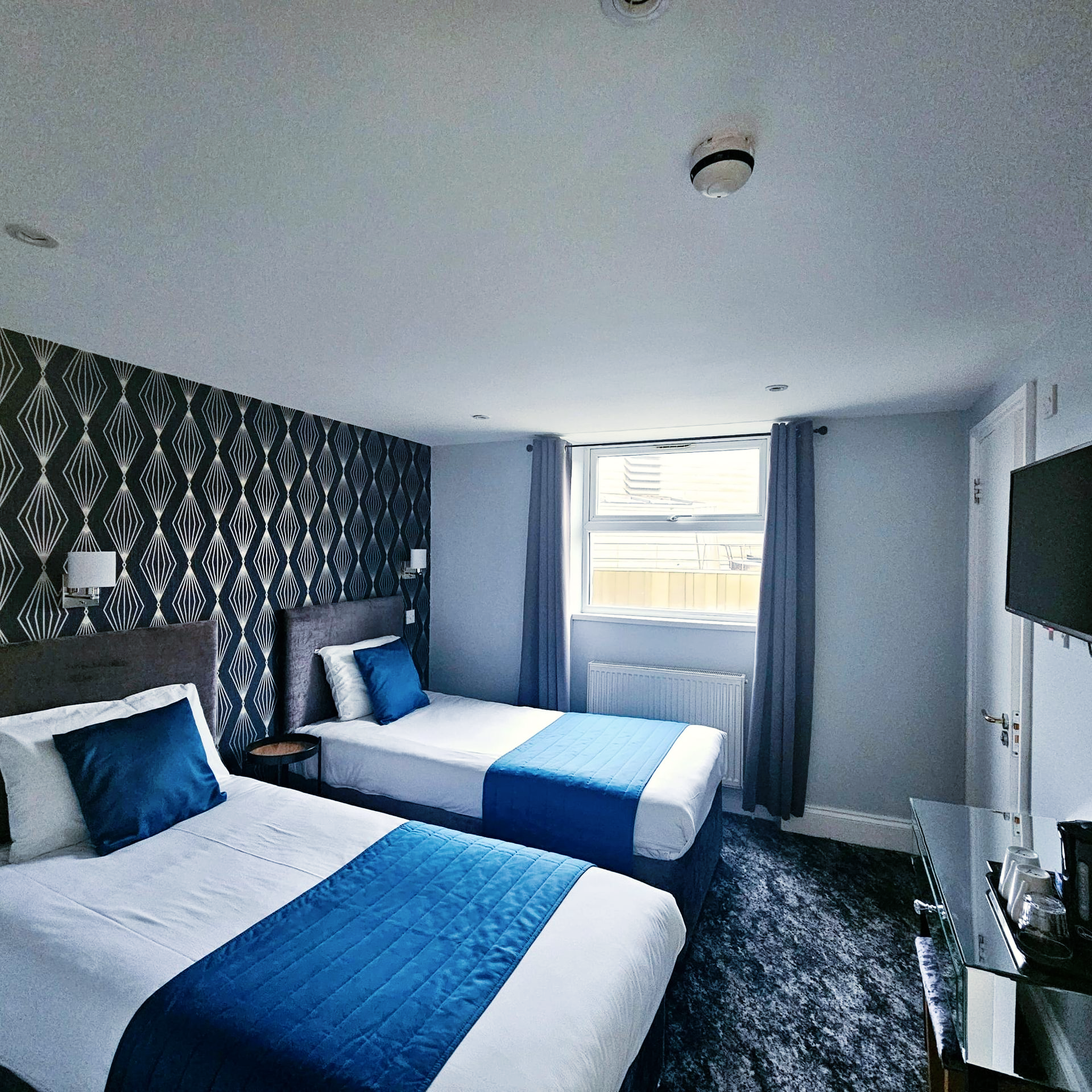 A hotel room with two beds and a television