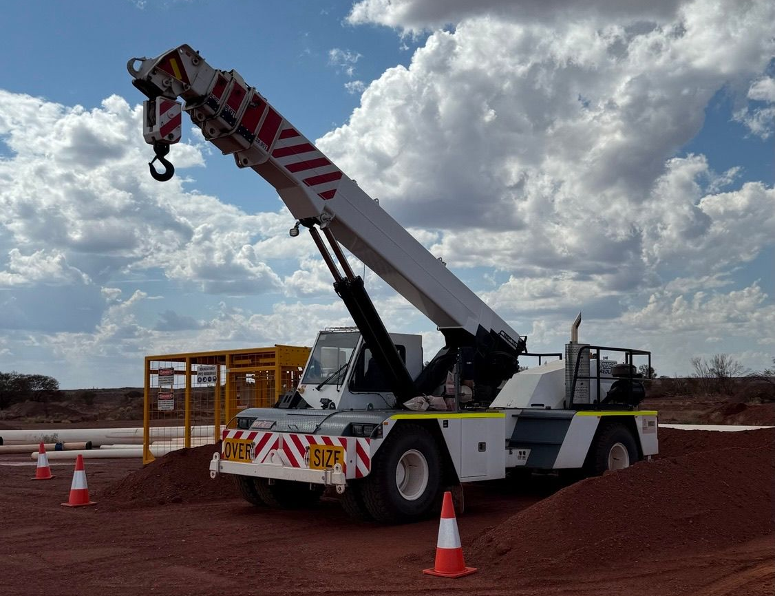 TB Plant Hire - Float and Delivery Solutions A truck is carrying a bulldozer on a trailer on a highway.