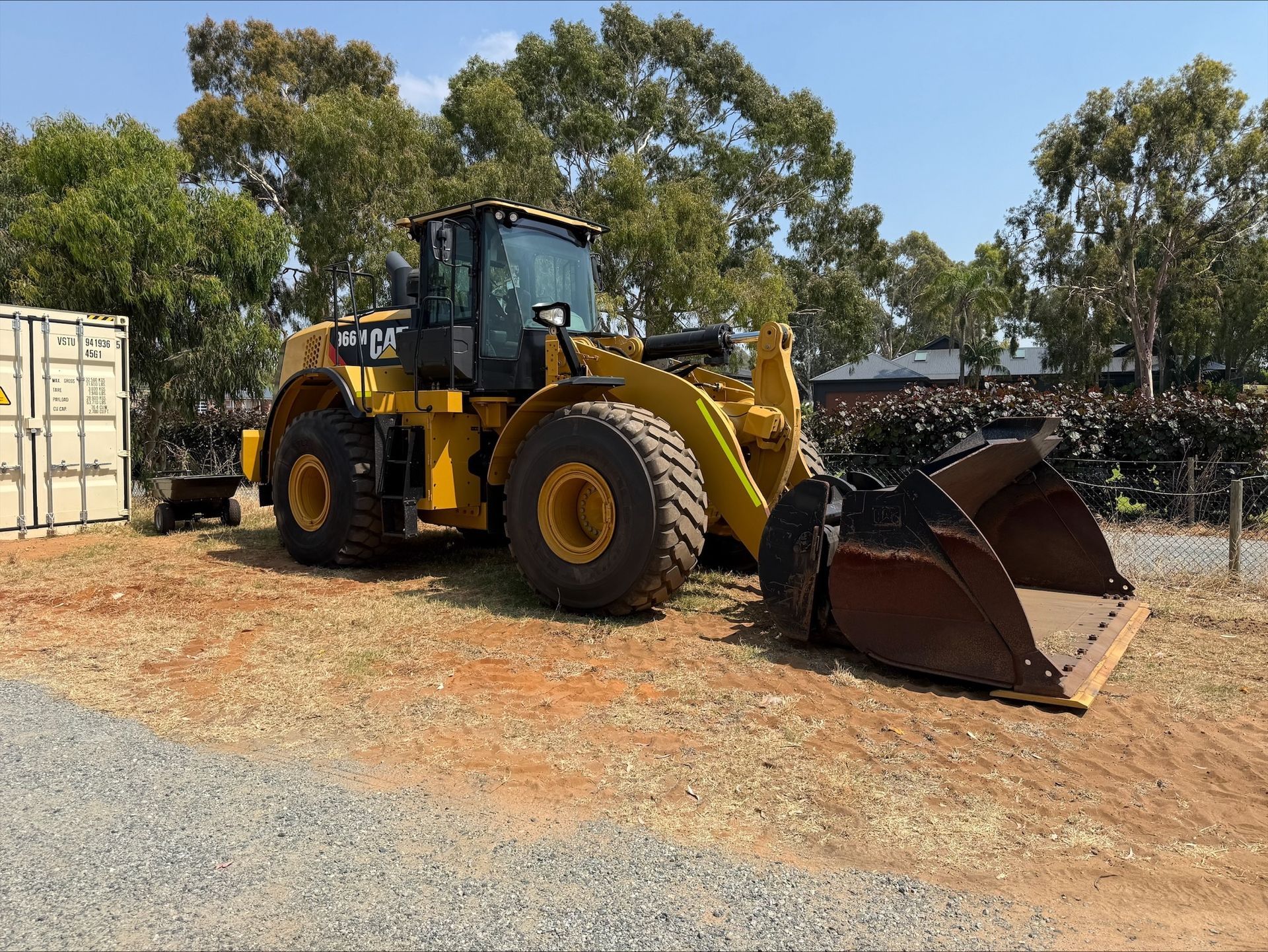 A large yellow excavator is working on a construction site.