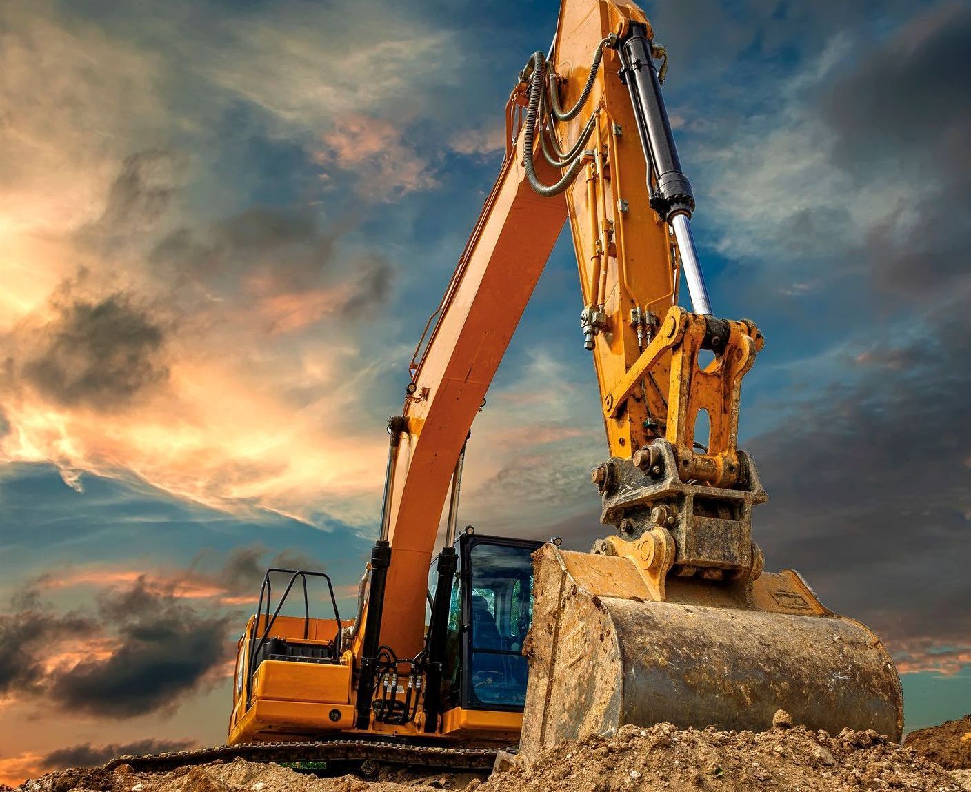 A large yellow excavator is working on a construction site.