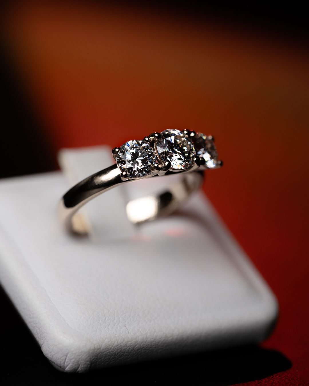 Un anello di diamanti è appoggiato su una scatola bianca