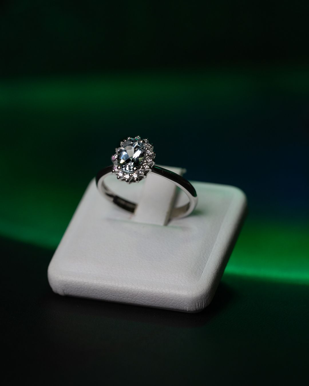 Un anello di diamanti è appoggiato su un porta anelli bianco