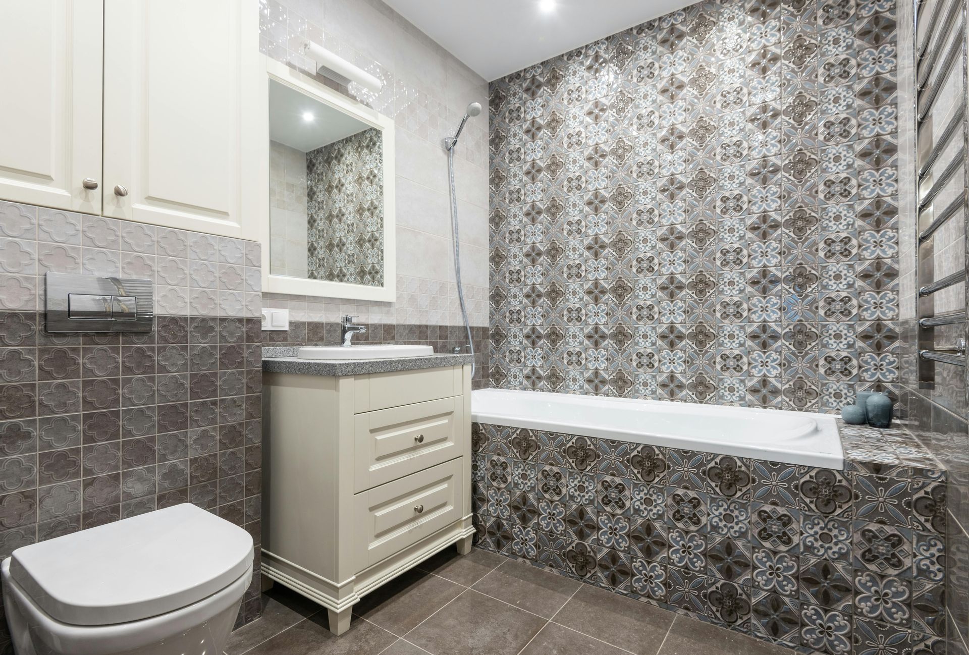 Accessible bathroom with shower, toilet, vanity, and patterned tile walls