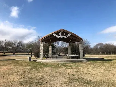 Burleson Electrician -Entrance archway to Chisenhall Fields with text on top, surrounded by manicured lawns and a bright blue sky with clouds.