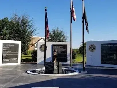 Burleson Electrician - A memorial site with flagpoles and plaques honoring military service. Flags include the United States and others.