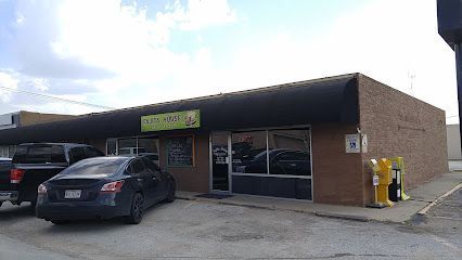 Burleson Electrician -A round black picnic table with attached seats is set on lush green grass, surrounded by leafless trees under a clear blue sky.