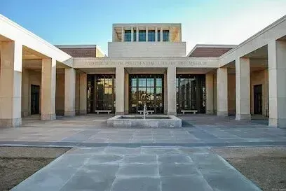 Burleson Electrician - Wide view of a neoclassical building entrance with tall columns, large glass doors, and a central courtyard. The scene feels formal and grand.