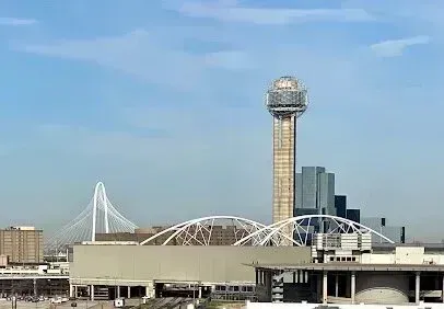 Burleson Electrician -Dallas skyline with the Reunion Tower, a spherical observation structure, and the Margaret Hunt Hill Bridge under a clear blue sky, conveying urban vibrancy.