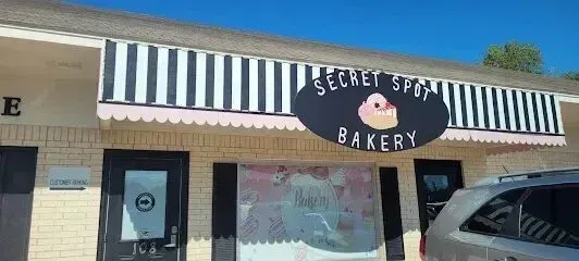 Burleson Electrician - A bakery storefront with a black-and-white striped awning, scalloped trim, and a sign reading 