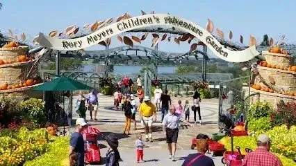 Burleson Electrician - Playground scene with children on a blue slide and swings. A colorful climbing structure sits nearby. 