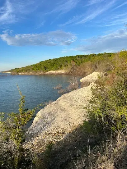 Burleson Electrician - Sunny day at a water park with a large, empty shallow pool surrounded by sun loungers and tiki-style huts.