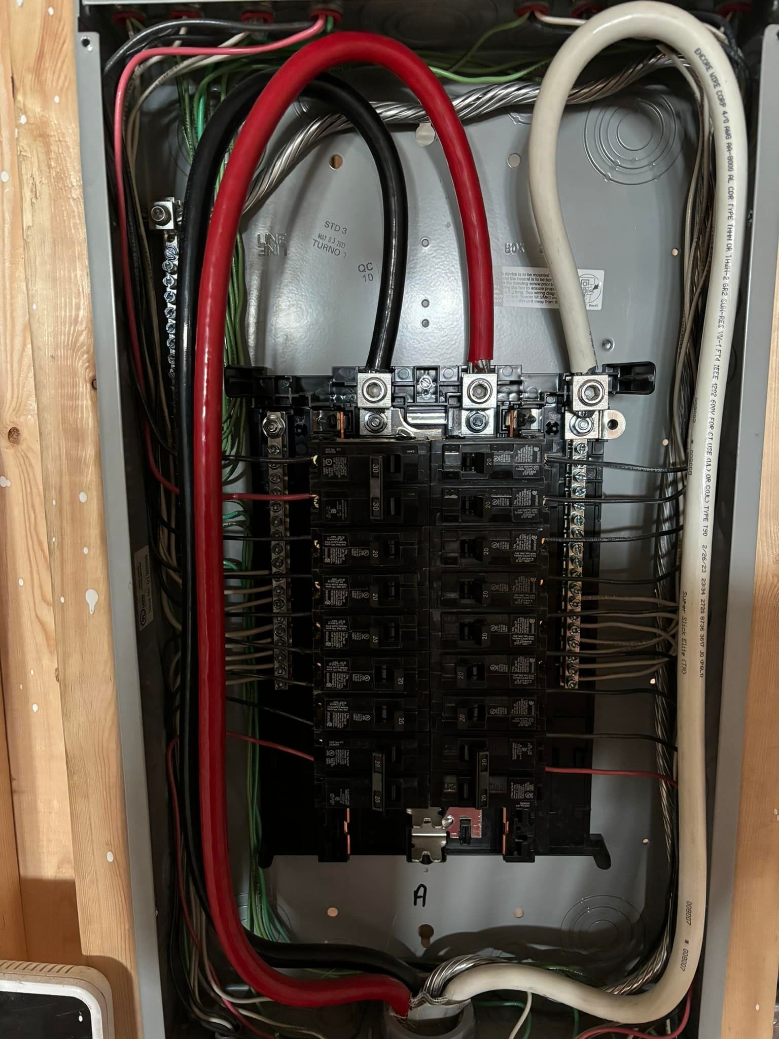 Electrical panel with black and red wires connected to breakers, white wire on the right.