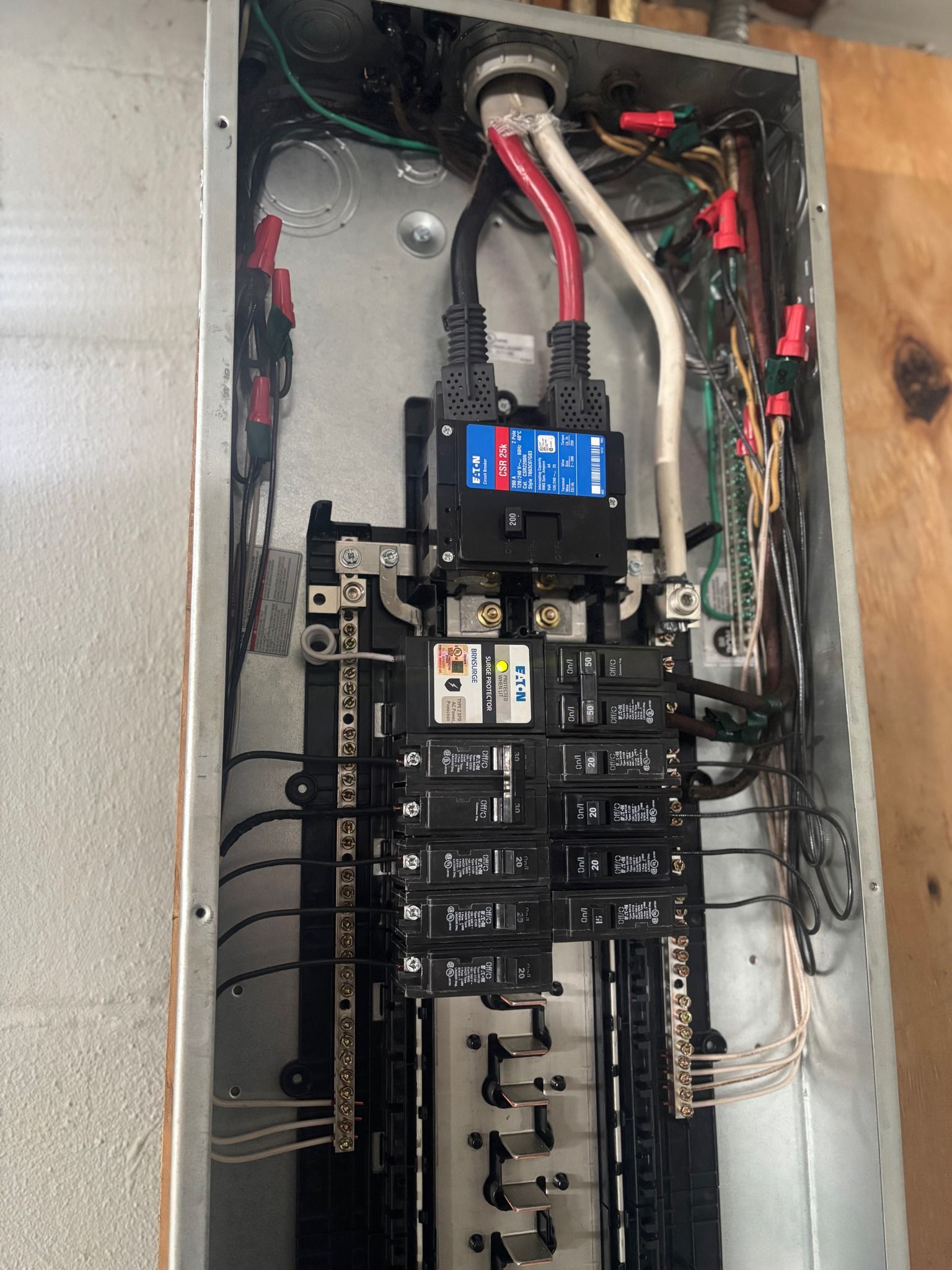 Electrical panel with black circuit breakers and wiring.