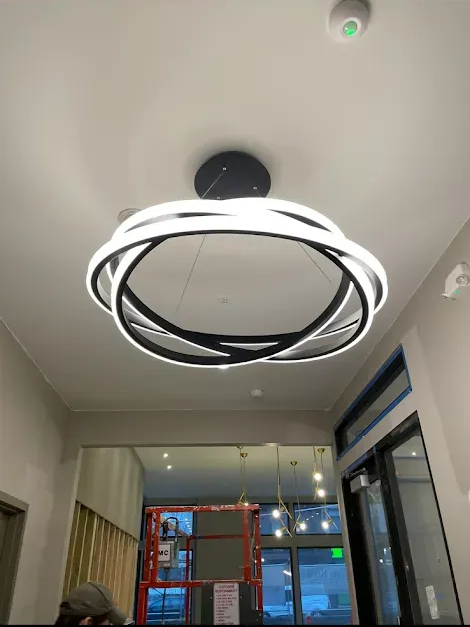 Silver Ring video doorbell mounted on a black door frame. The doorbell has a button and camera.