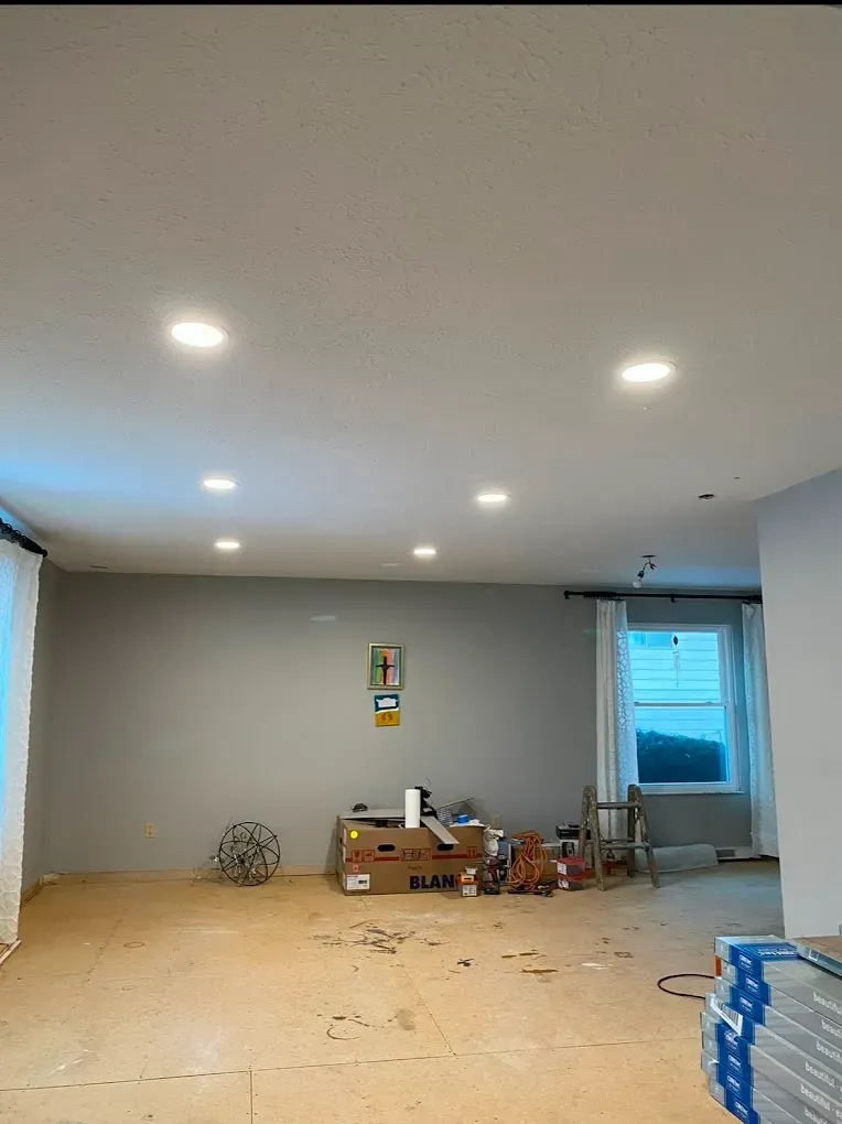 Empty room with recessed lighting, gray walls, unfinished flooring, and a window.