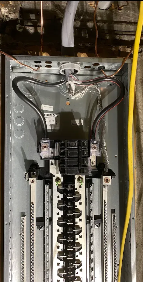 Electrical panel with wires and circuit breakers.