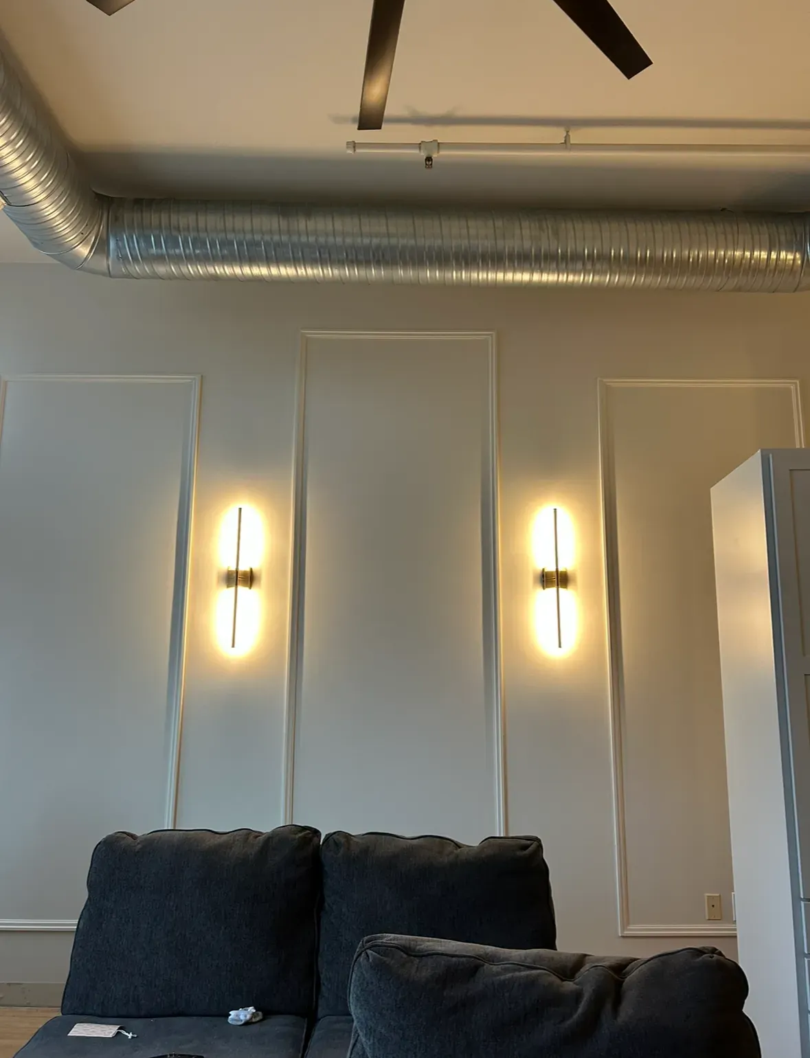 Orange electrical outlet tester plugged into a white GFCI outlet; green light is lit.