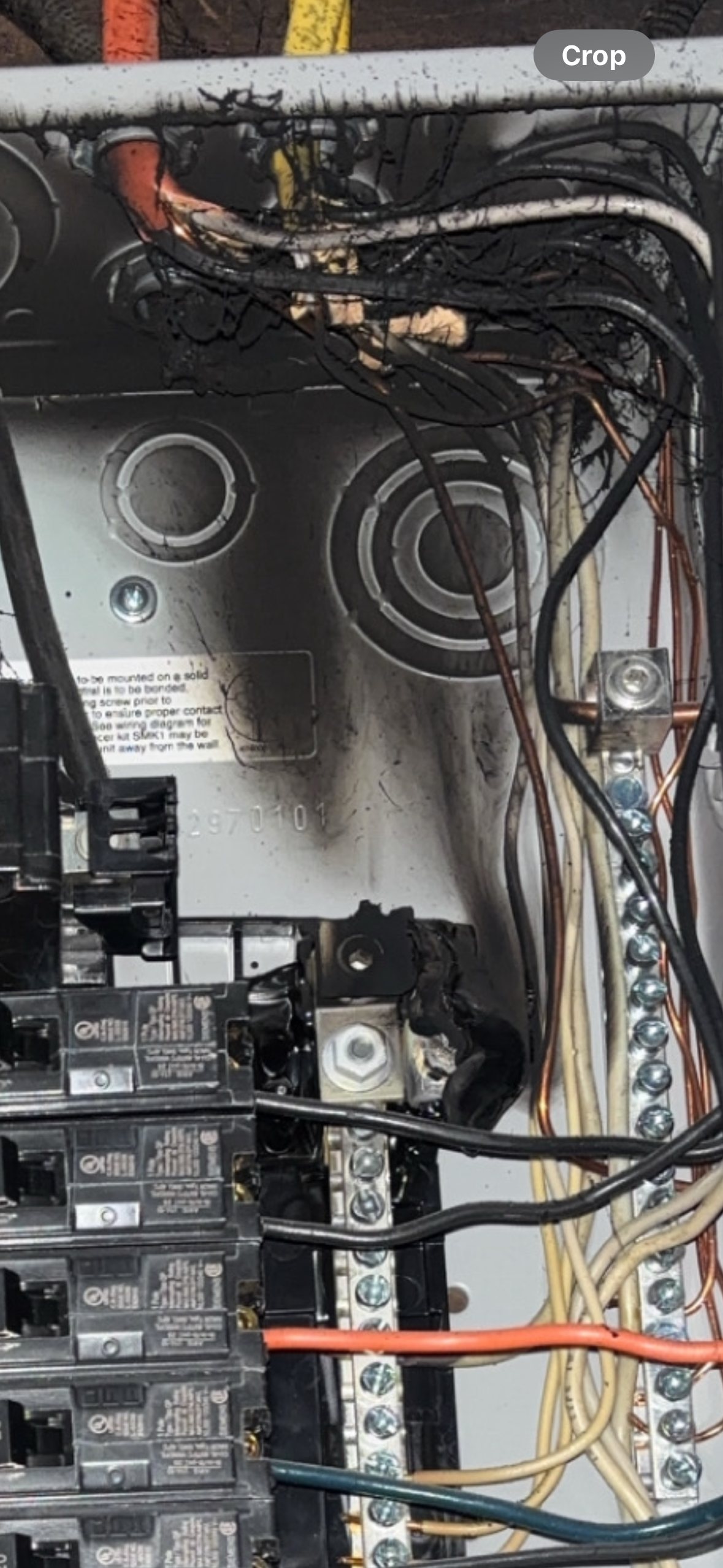 Burned electrical panel with charred wires and components.