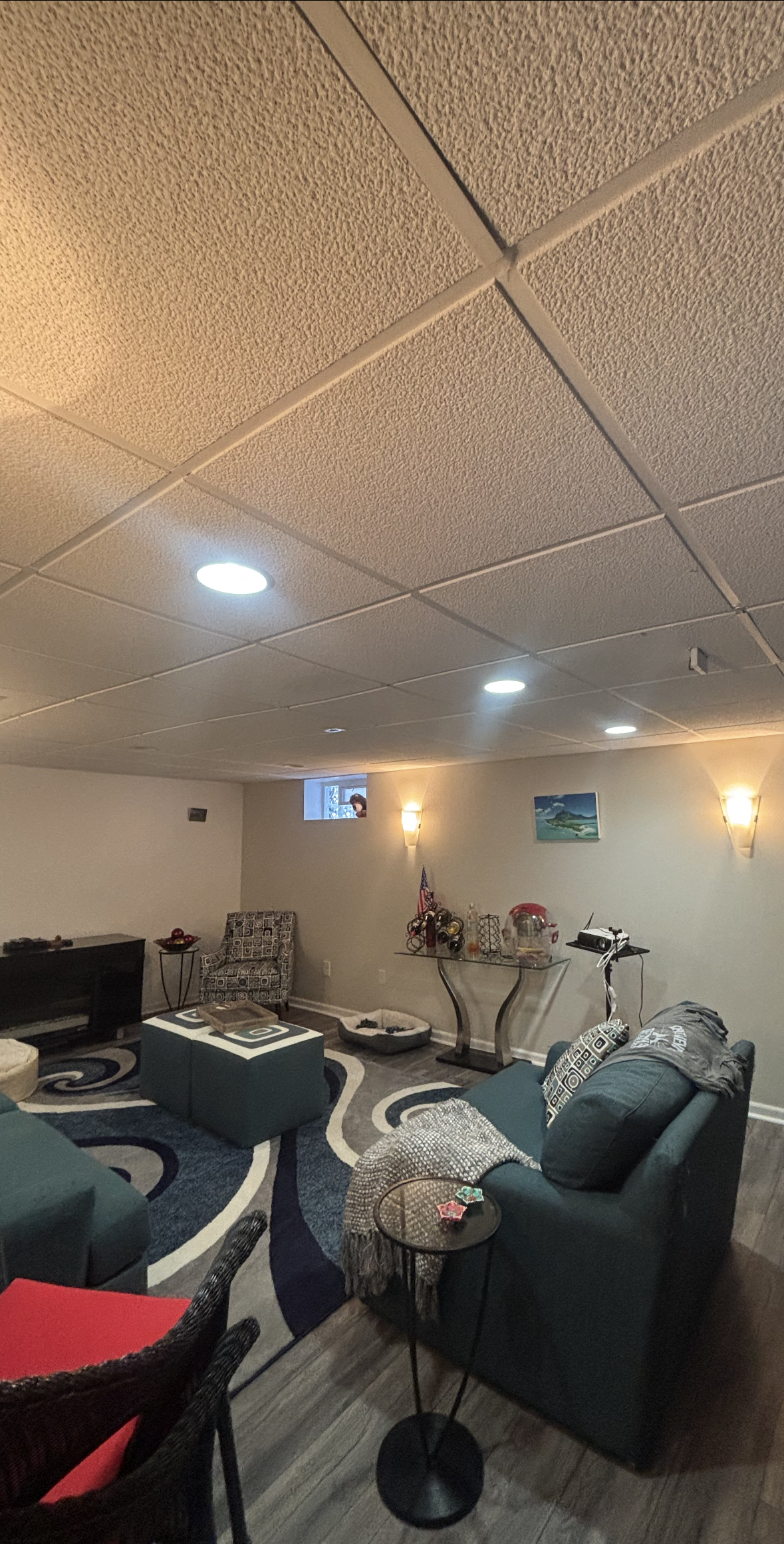 Living room with blue sofas, patterned rug, and textured ceiling.