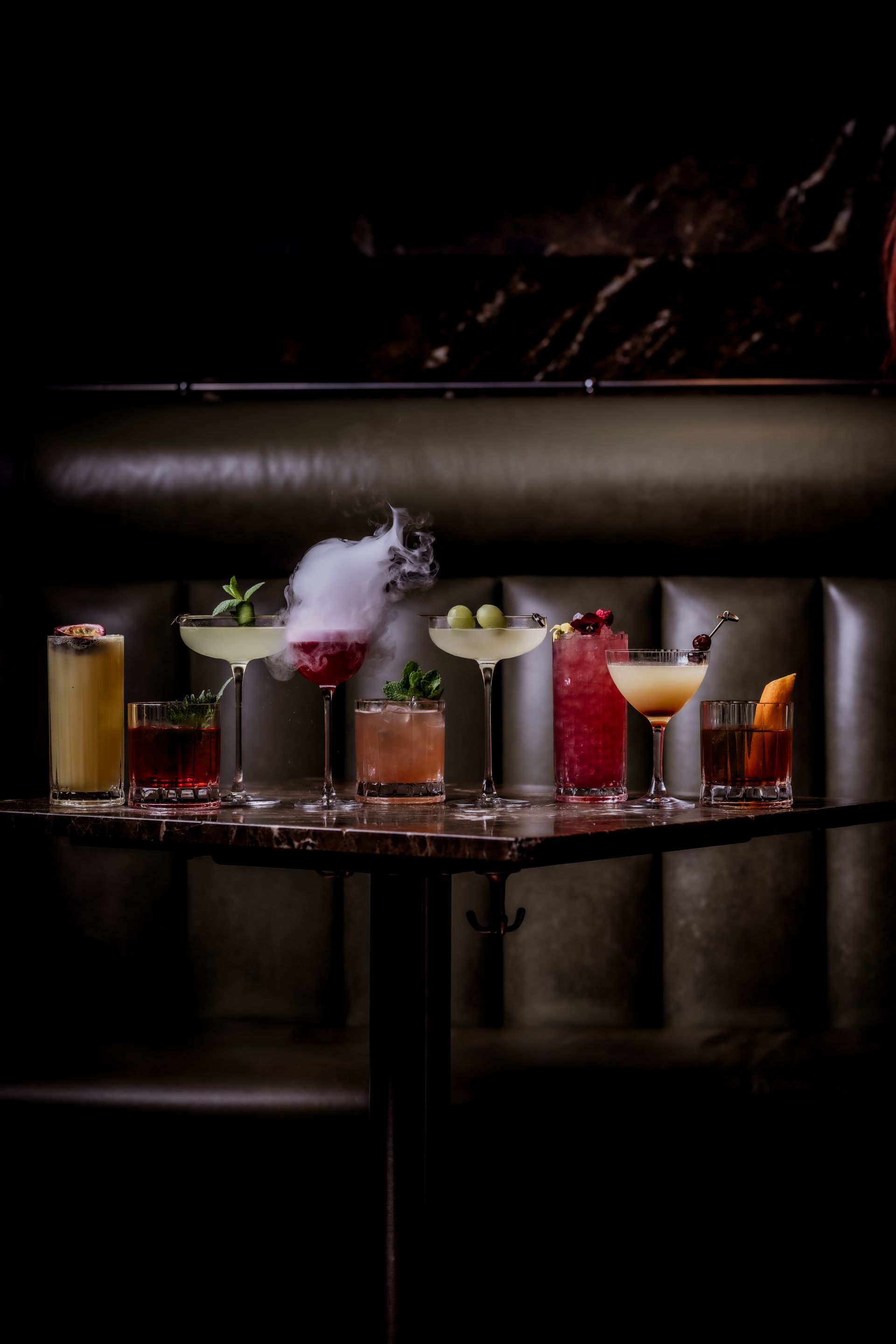 Restaurant interior with diners at tables, server stands at center. Exposed brick, industrial ceiling.
