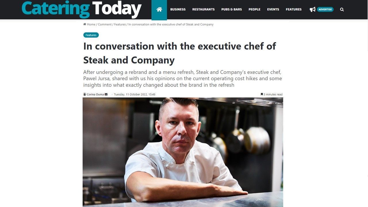 Executive chef from Steak and Company. In a kitchen, resting arm on a counter.