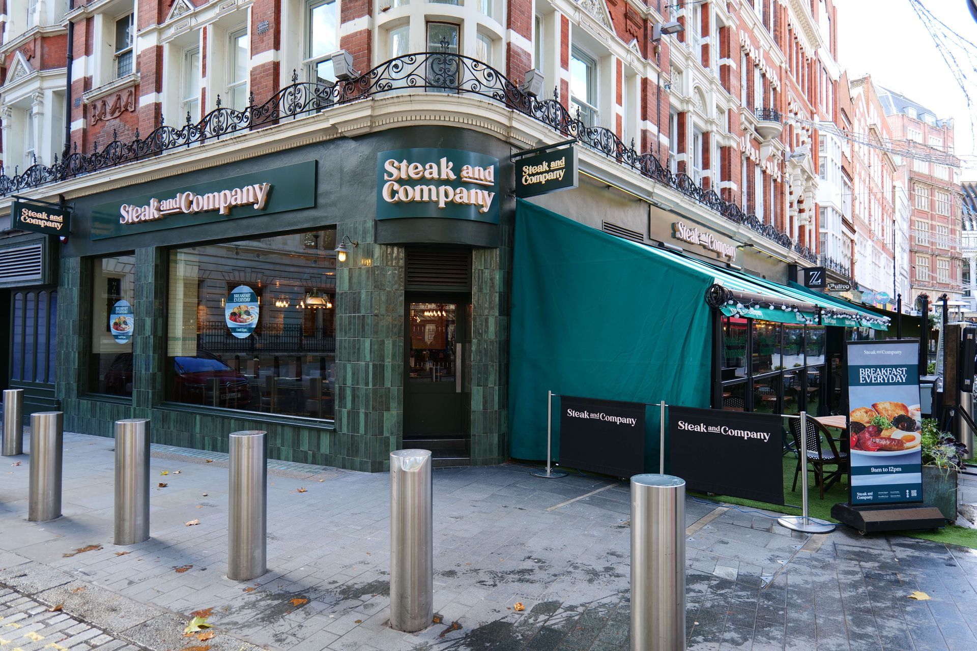 Restaurant interior with diners at tables, server stands at center. Exposed brick, industrial ceiling.