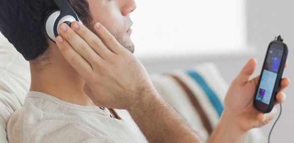 Man is listening audio song by headphone through mobile in Auckland, Ellerslie