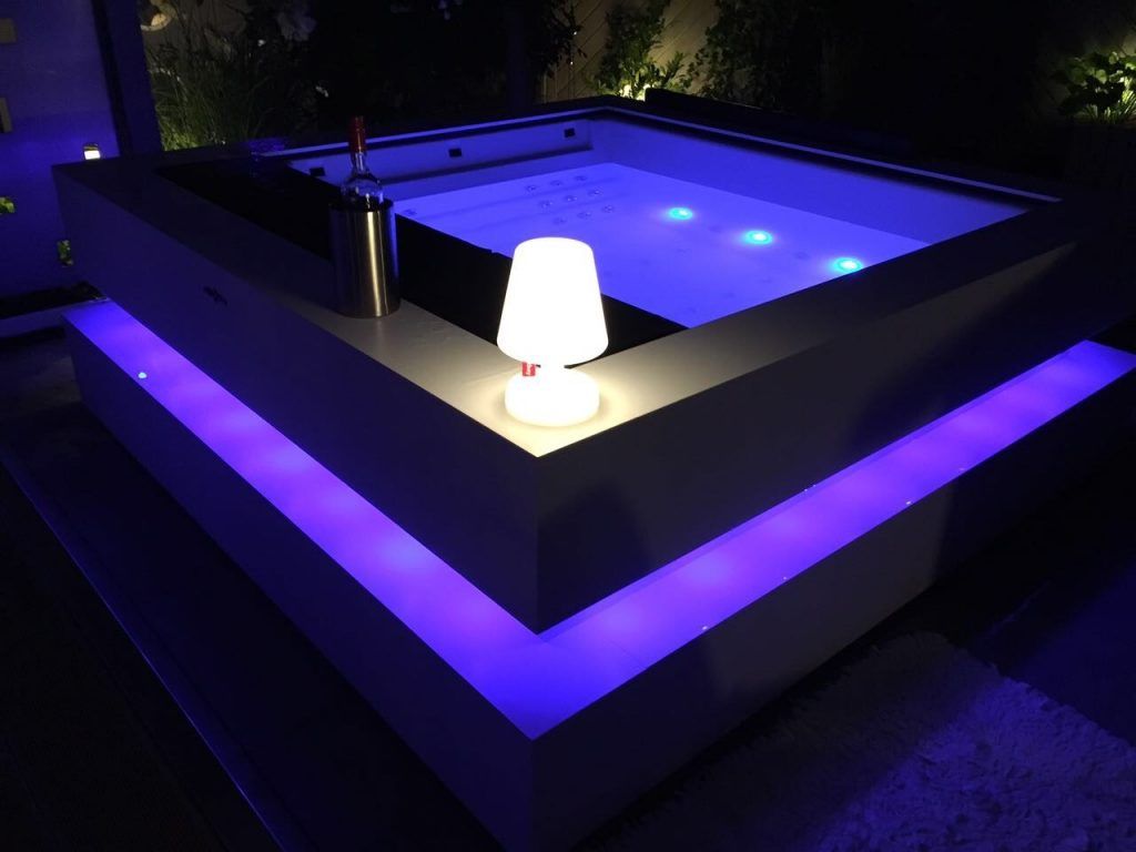 a hypa spa hot tub lit up at night