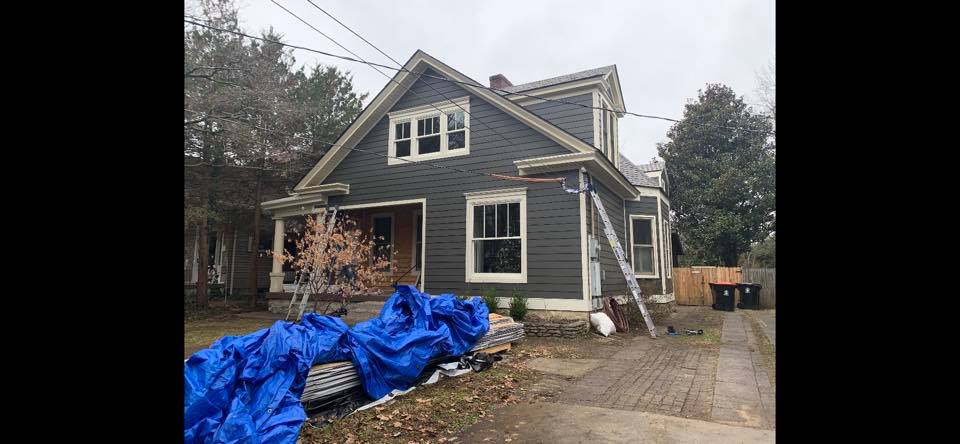 A house with a blue tarp on the side of it.