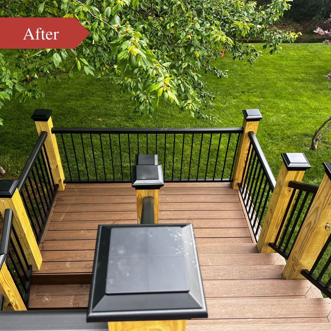 A wooden deck with a black railing and stairs leading up to it.
