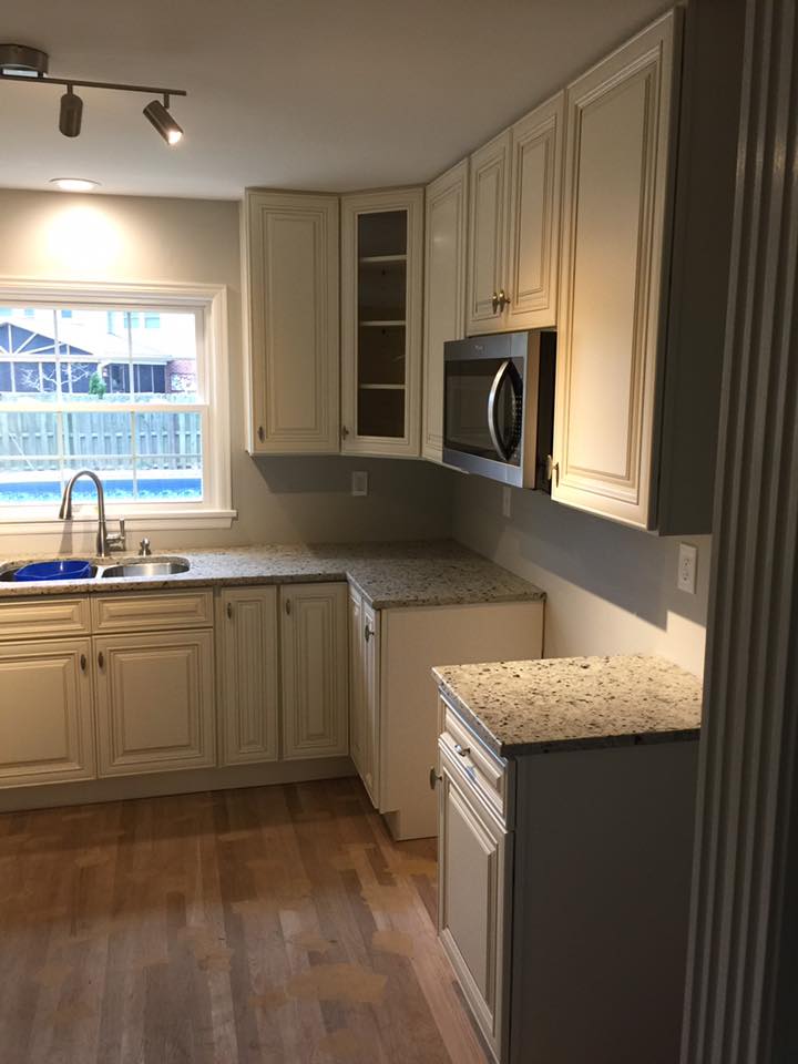 A kitchen with white cabinets and granite counter tops