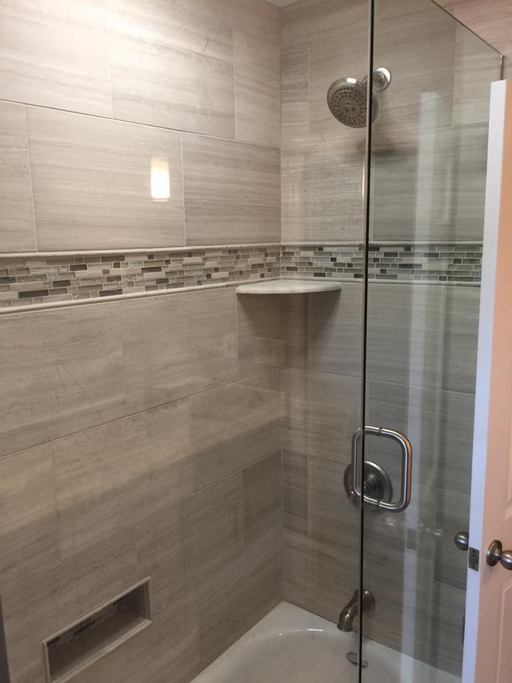A bathroom with a tub and a shower with a glass door.