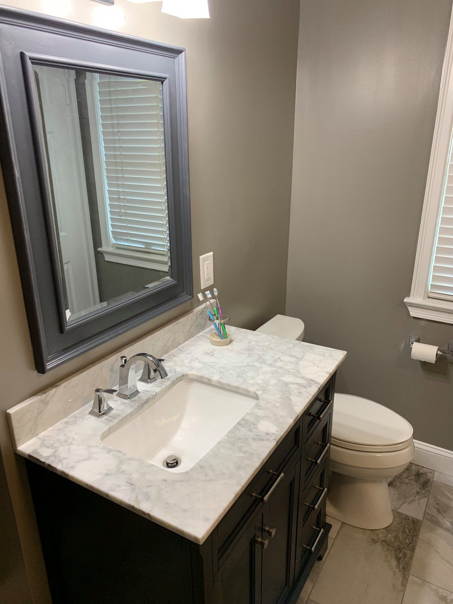 A bathroom with a sink , toilet and mirror.