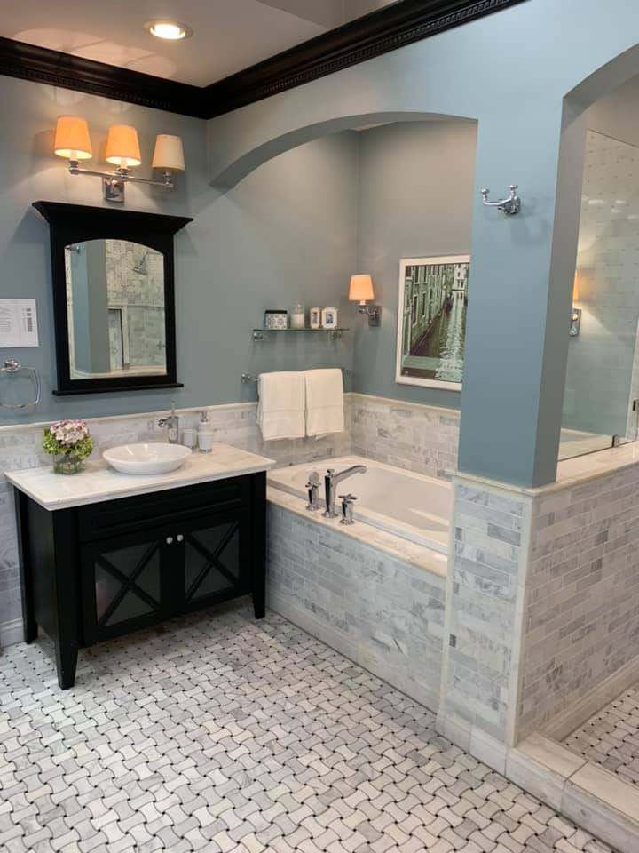 A bathroom with a sink a tub and a mirror