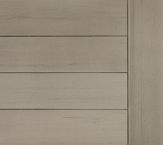 Close-up of a wooden door with horizontal planks on the left and a vertical panel on the right, light grey in color.