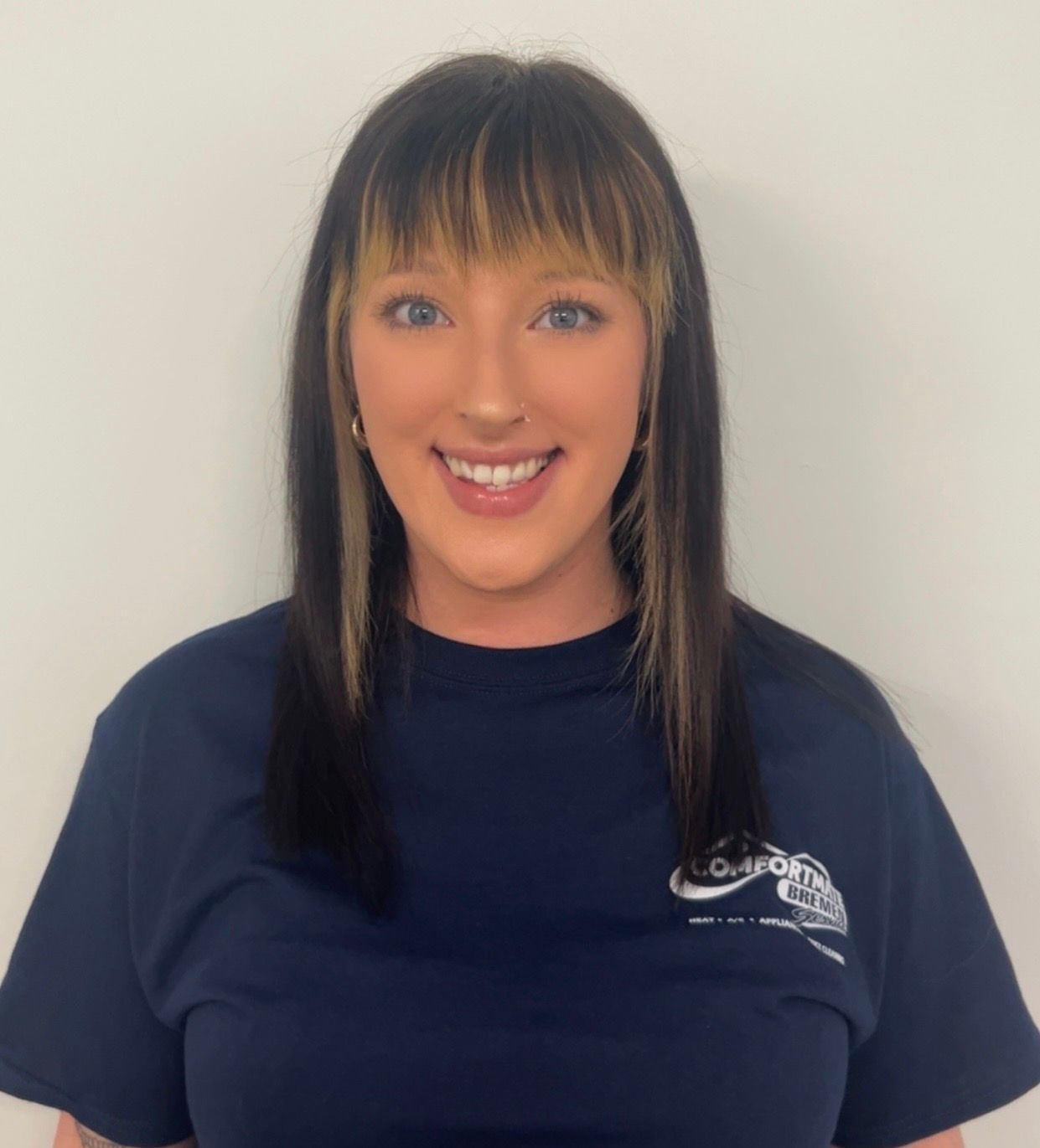 A woman wearing a blue shirt with a logo on it