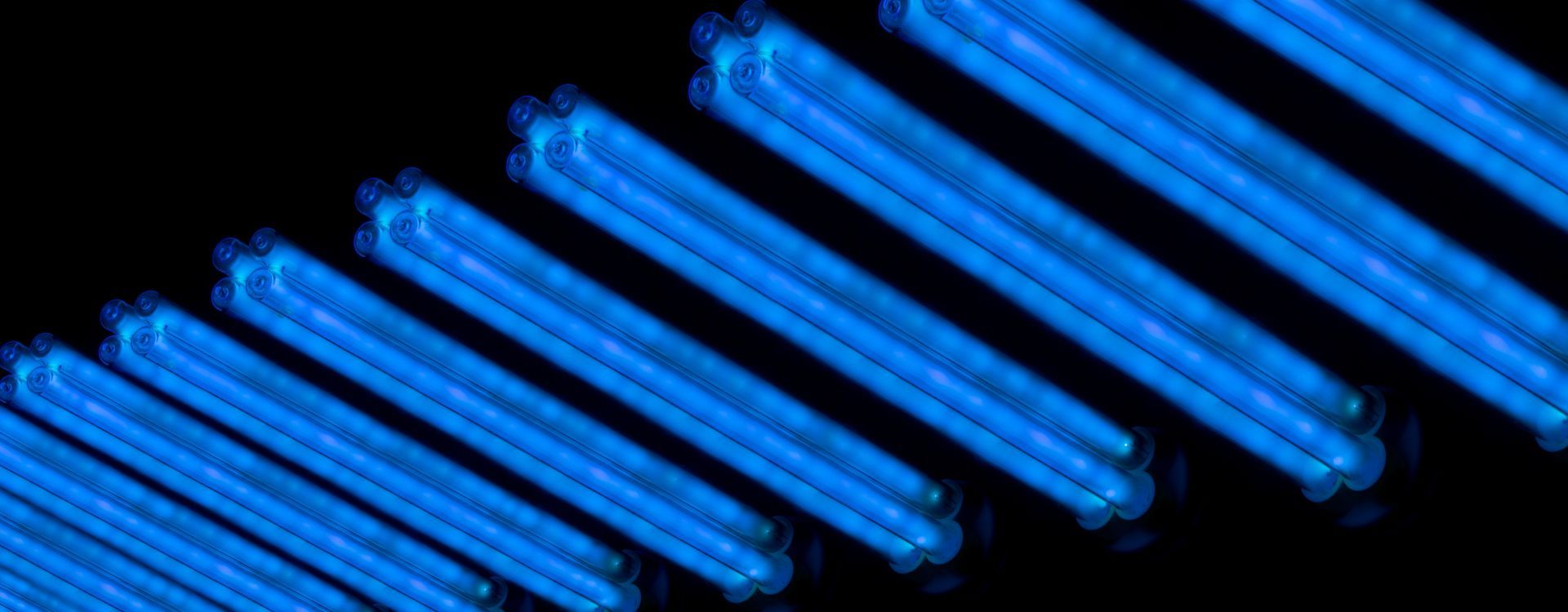 A close up of a row of blue lights on a black background.