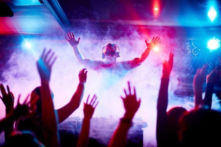 A dj is playing music to a crowd of people at a party.