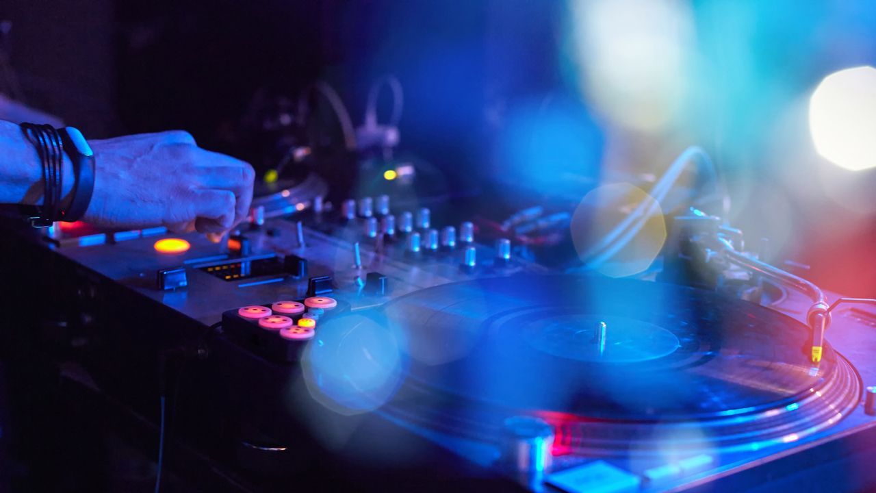 A dj is playing music on a turntable in a club.