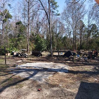 A Person Is Standing In The Middle Of A Dirt Field With Trees In The Background - Rebecca, GA - Cole and Jones Tree Services