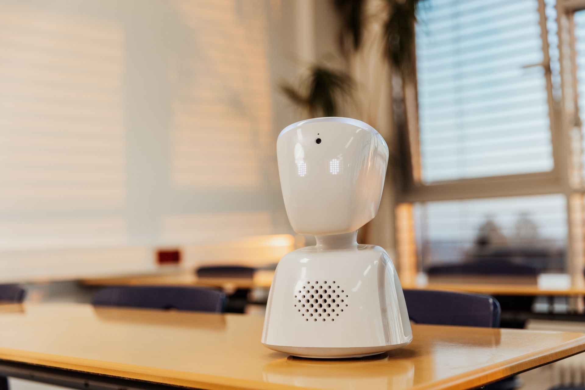 Un robot blanc est assis sur une table dans une salle de classe