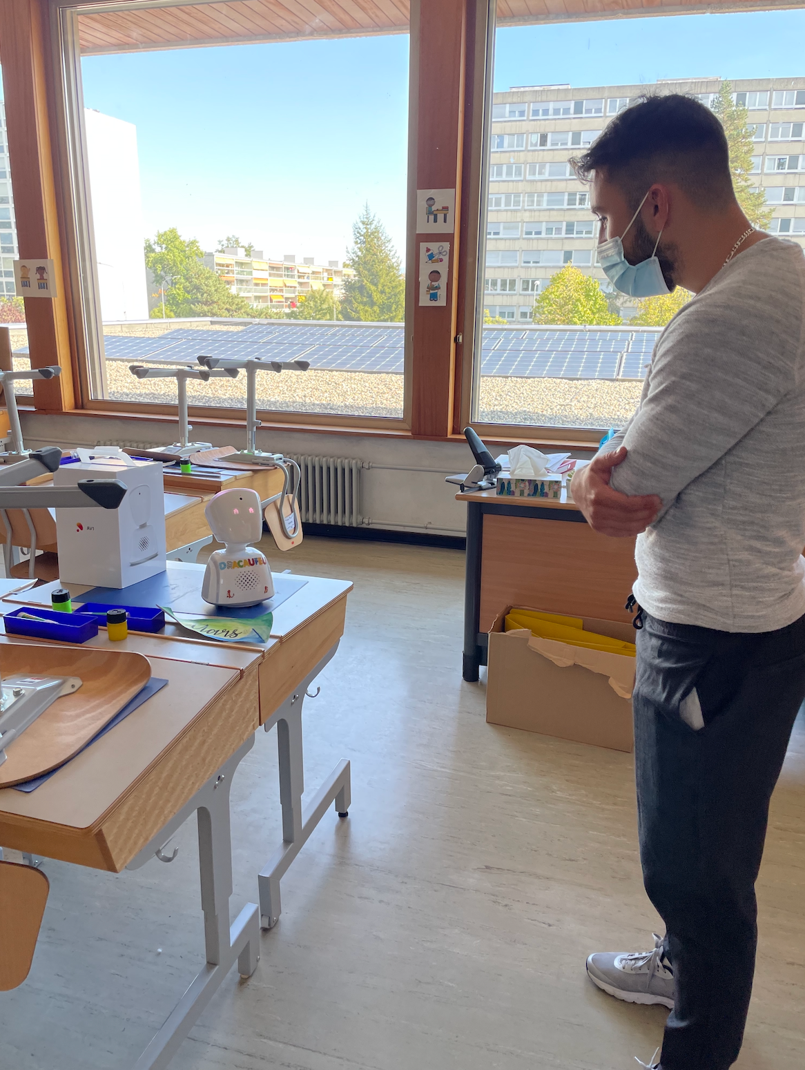 Un homme portant un masque se tient devant une table